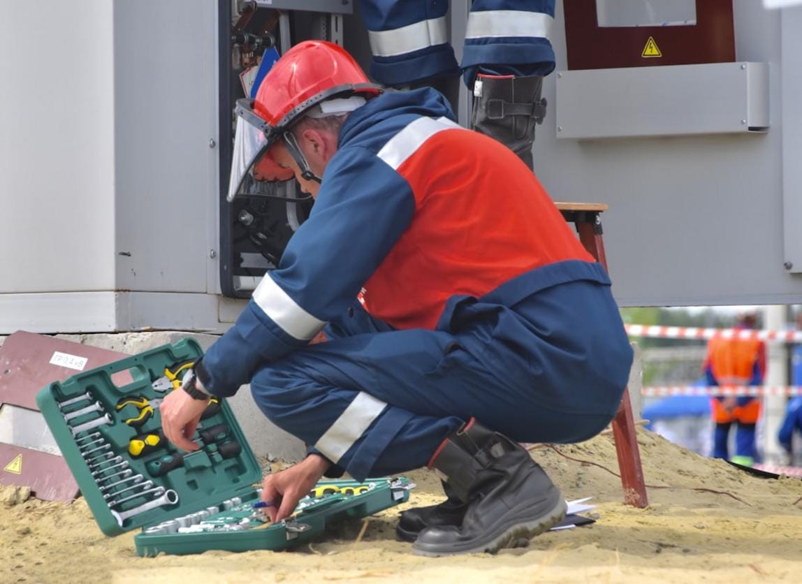 Technician performing routine maintenance on a large mixing-system in a concrete plant